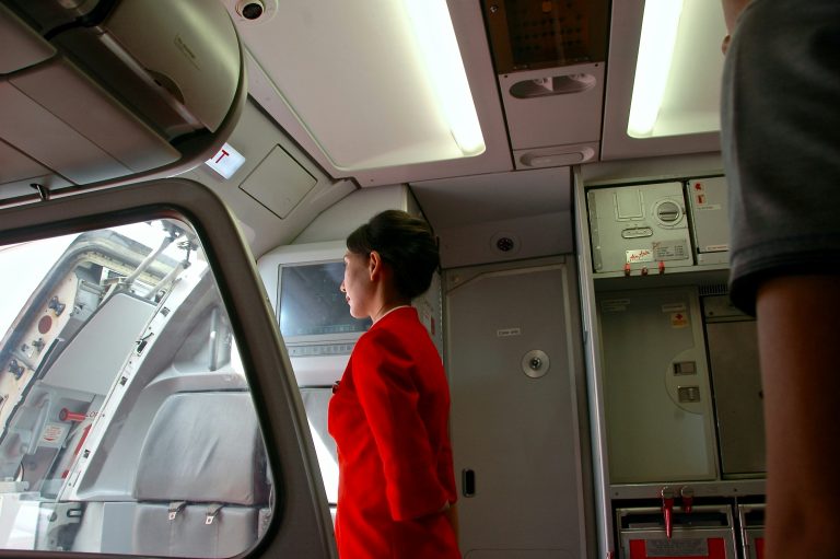 Airport Lingo | Flight attendant at airplane door | Evolve Tours