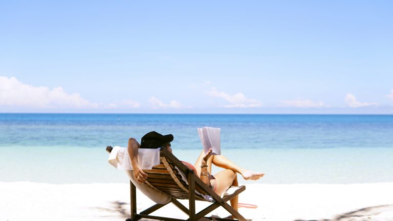 Getaway in your Life | Woman reading on a beach | Evolve Tours