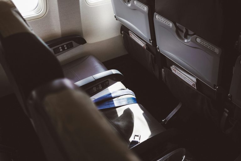 Travel Tips for Good Airplane Sleep | Row of airplane seats | Evolve Tours