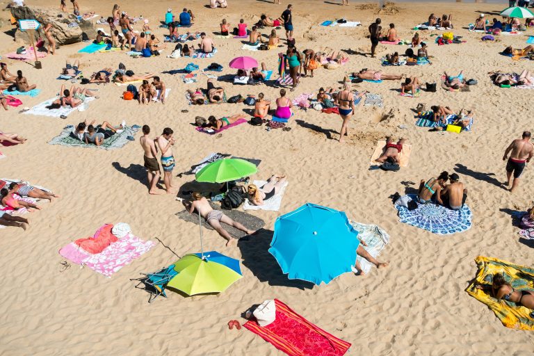 Long Weekend | Crowded beach on a sunny day | Evolve Tours
