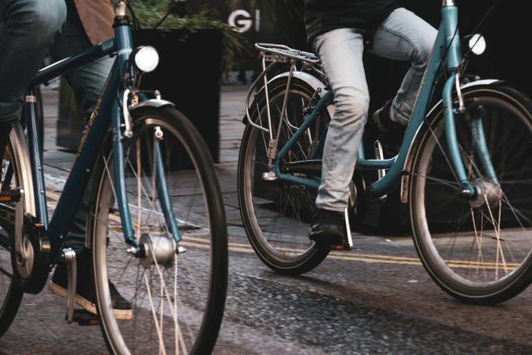Green Transportation Revolution | Closeup of two people biking on road | Evolve Tours