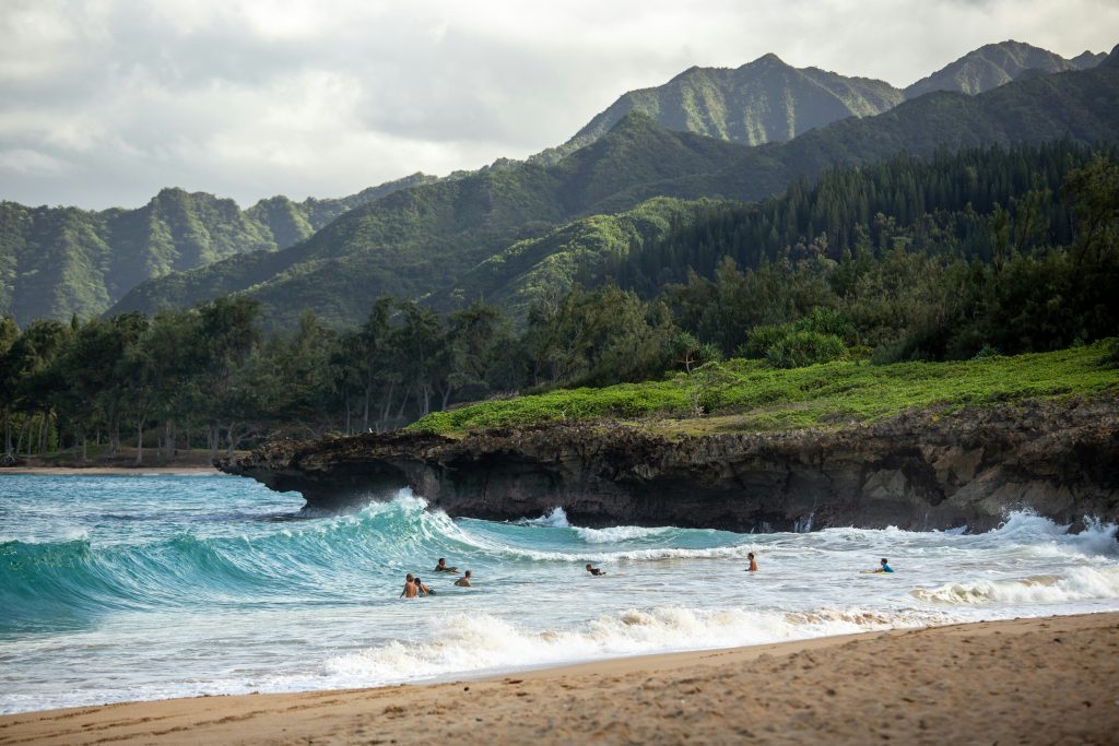 Hawaii Student Trip | Beach with green mountains in the background | Evolve Tours