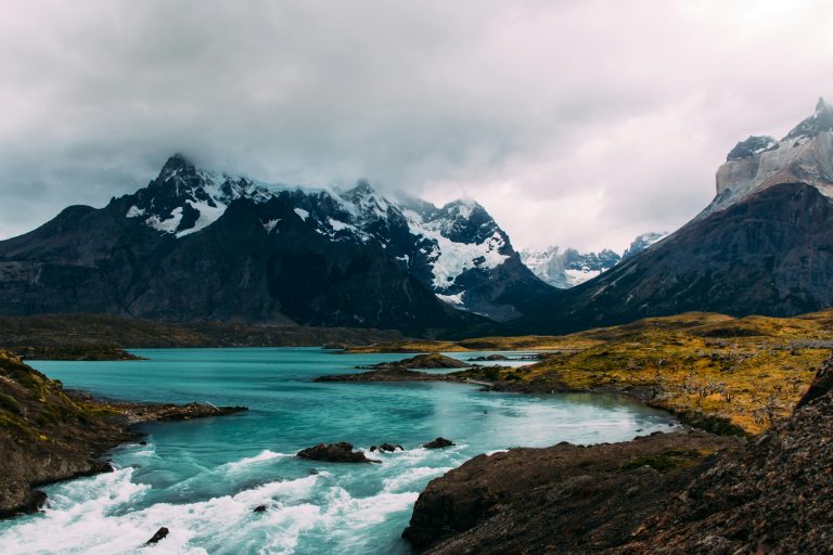 mountains and clouds behind blue running water