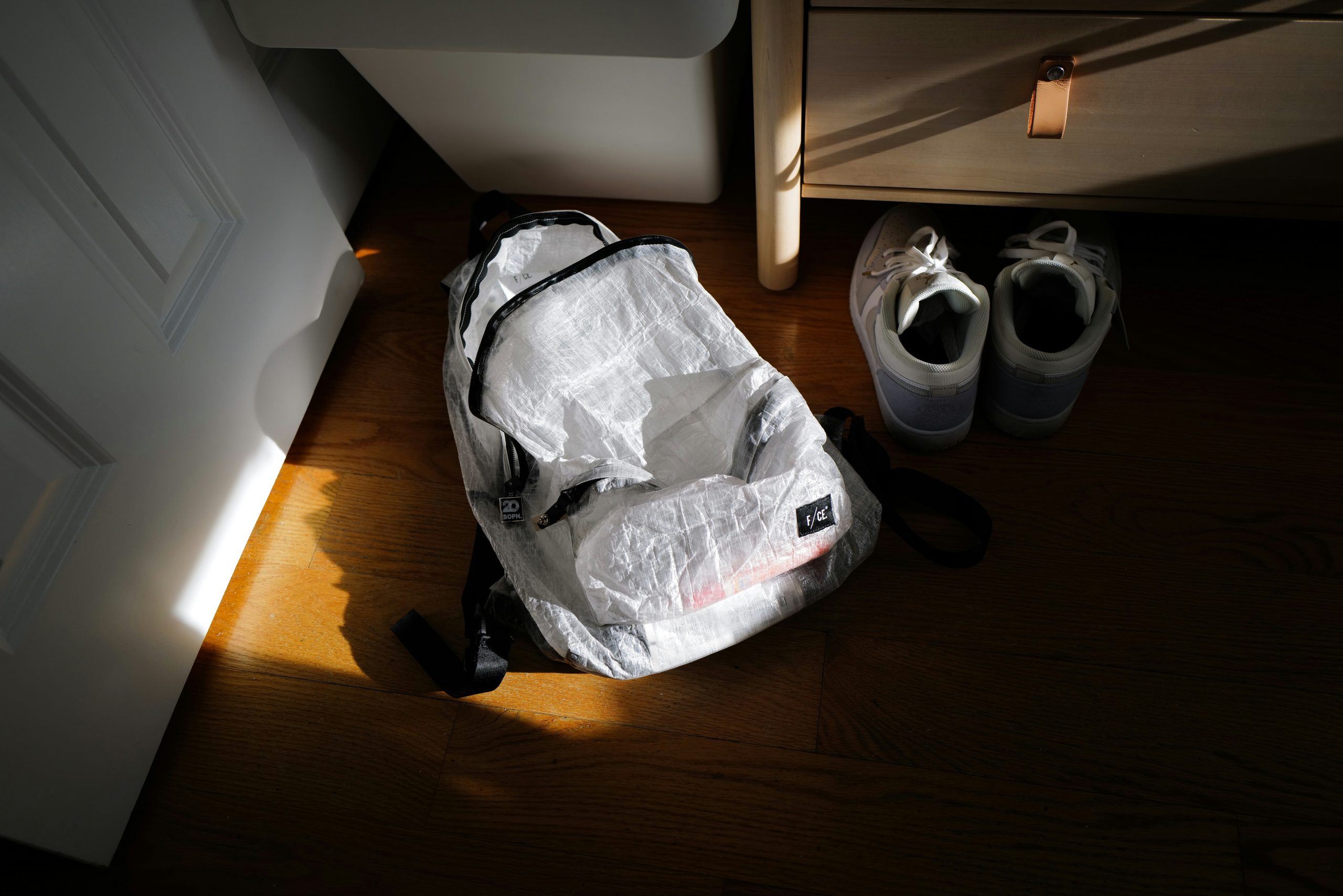Packing Light | White backpack next to running shoes | Evolve Tours